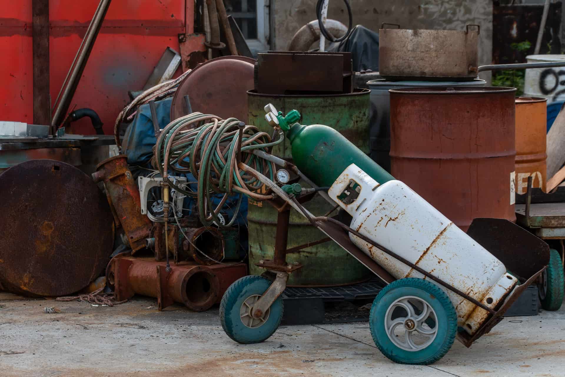 Shielding gas cylinders standing upright against a workshop wall