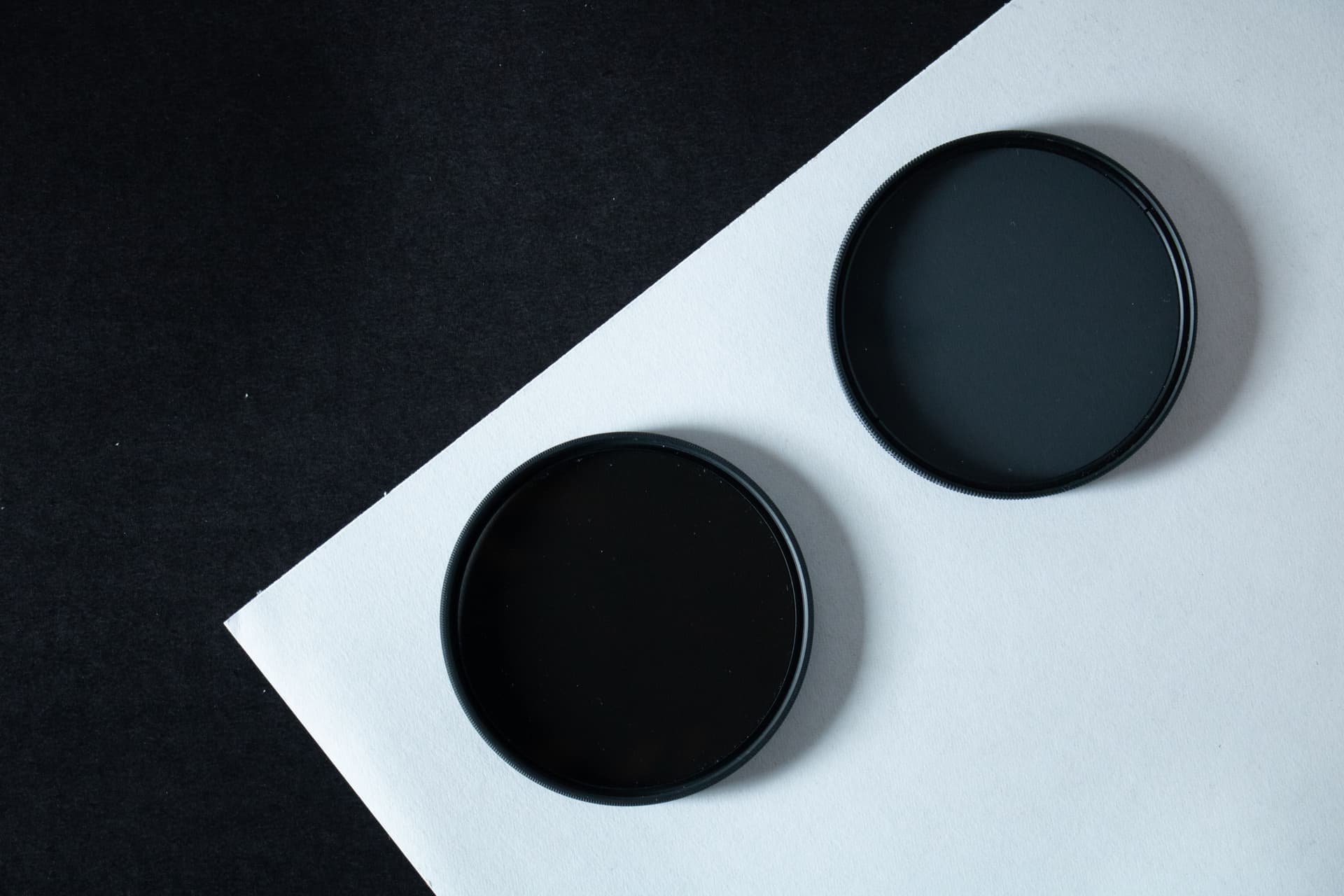 A dark welding filter lens held against a light background
