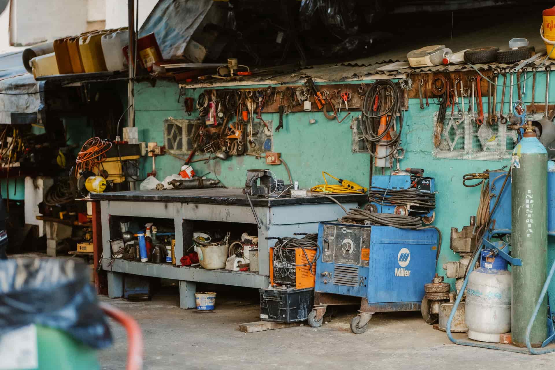 A compact flux-core wire-feed welder standing on a wooden workbench