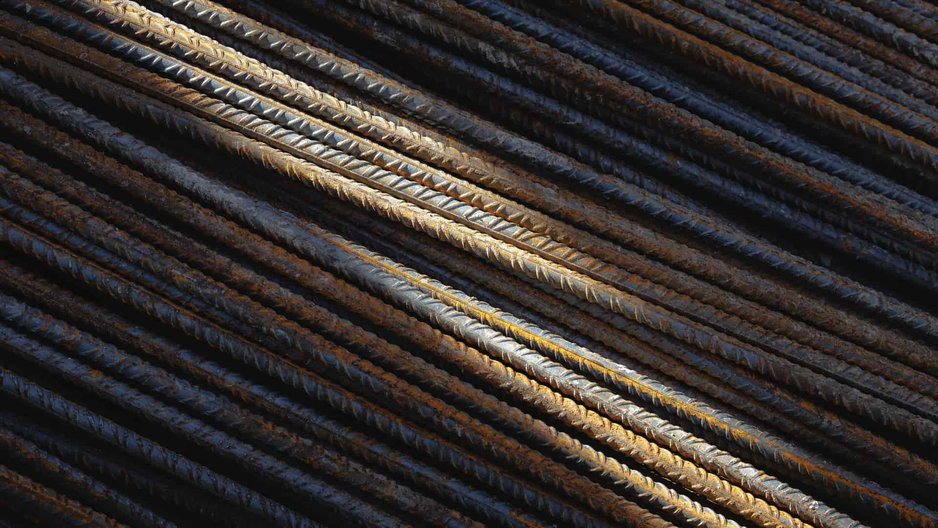 Tungsten electrodes laid out in a row on a light surface beside a TIG torch head
