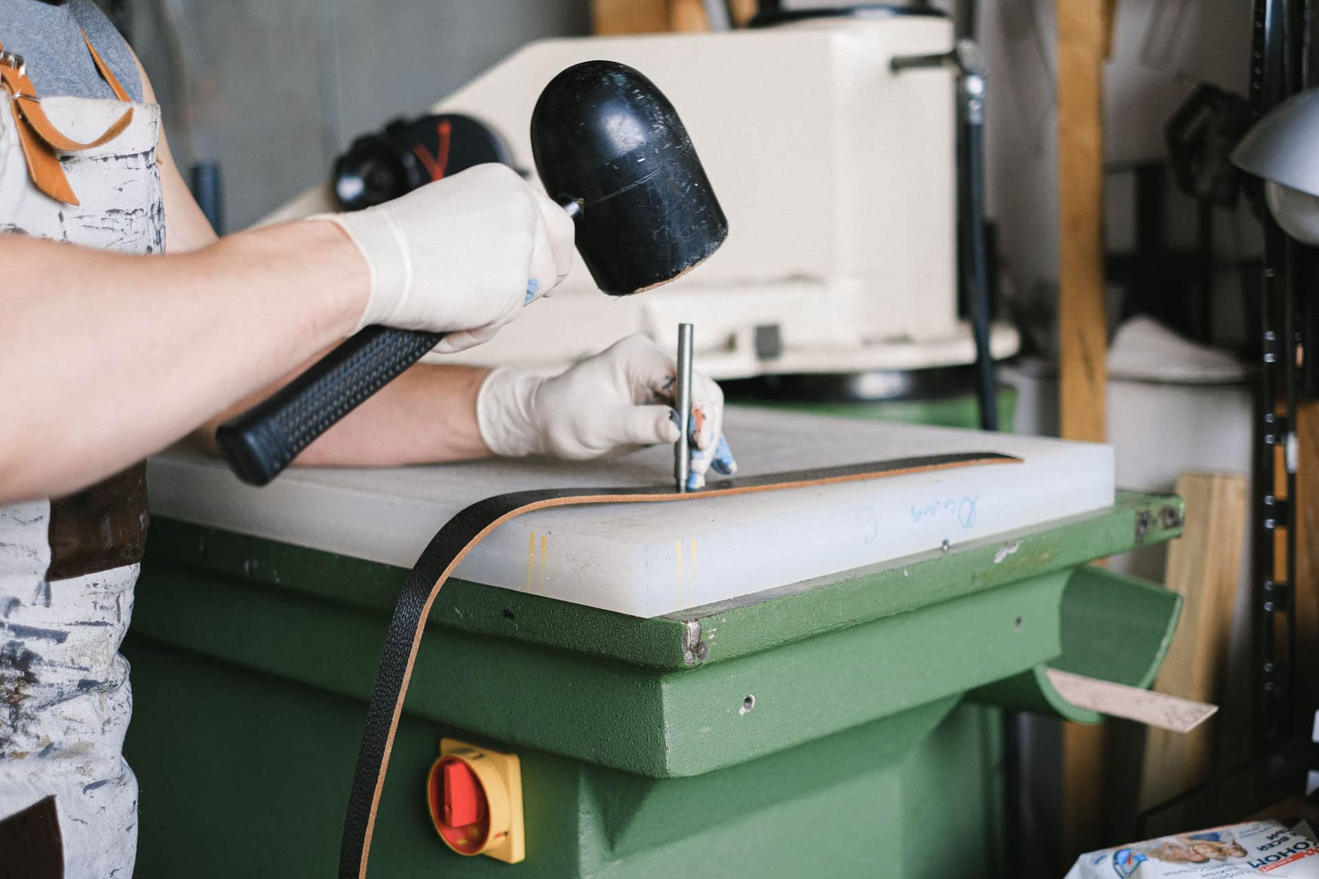 A pair of heavy leather welding gloves resting on a workbench