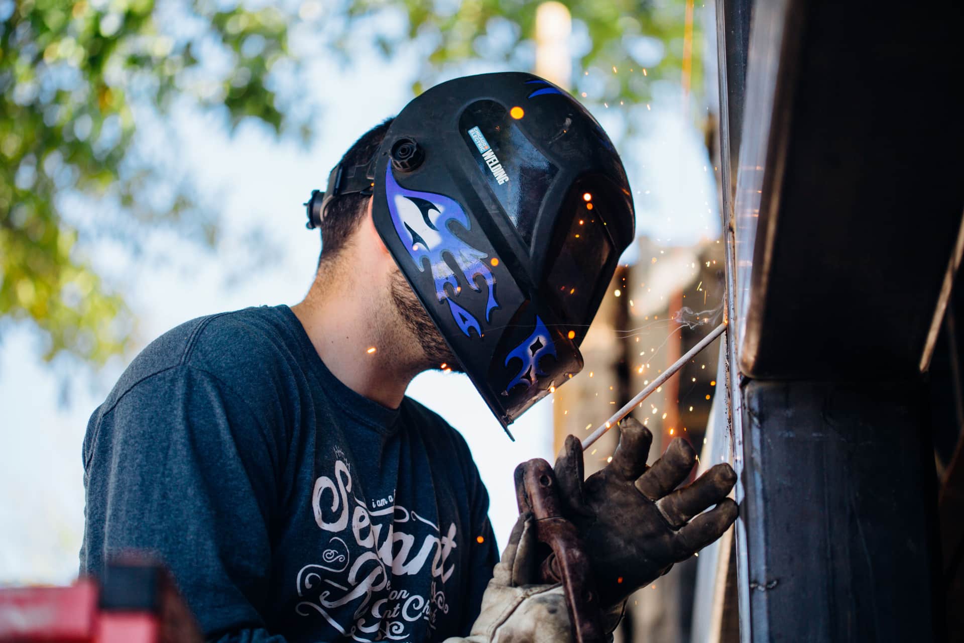 An auto-darkening welding helmet resting on a pale workshop surface